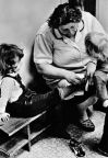 Kindergärtnerin zeigt, wie man sich Schuhe anzieht - 1977